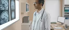 врач смотрит на рентген мозга пациента с демиелинизирующим заболеванием